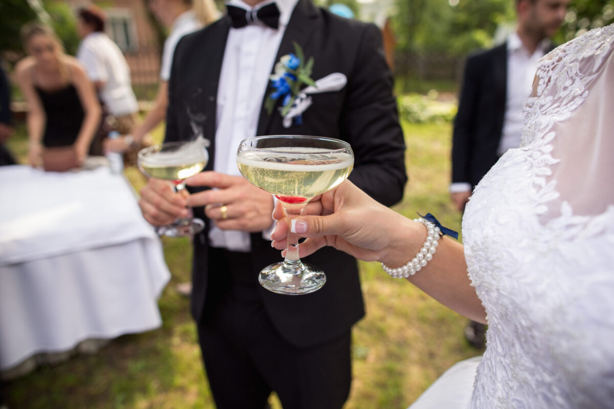 Bride and Groom in wedding attire holding champagne