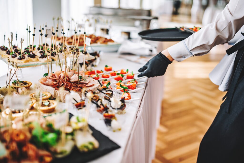 Female,Hands,Of,A,Waiter,Prepare,Food,For,A,Buffet