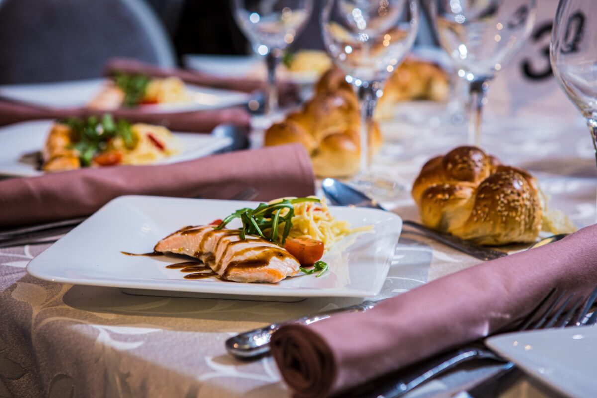 Event cutlery and place setting with salmon and vegetable dinner plates and roll